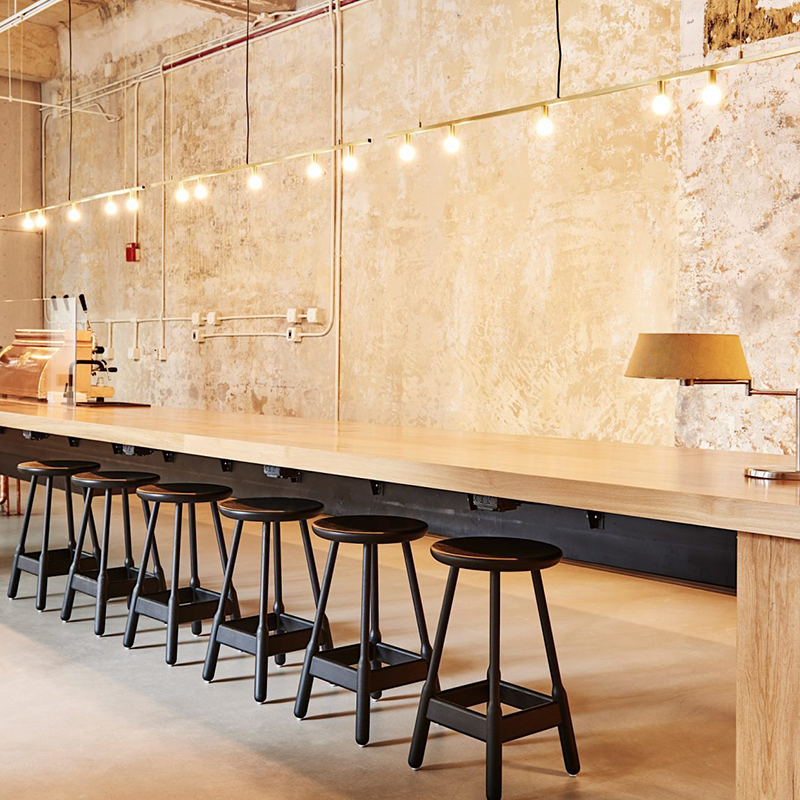 歴史ある建物のテクスチャーとモダンな家具とのコントラストが迎えるホステルの店舗デザイン