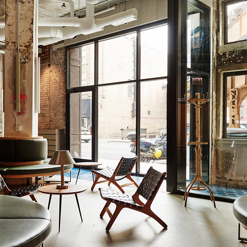 歴史ある建物のテクスチャーとモダンな家具とのコントラストが迎えるホステルの店舗デザイン