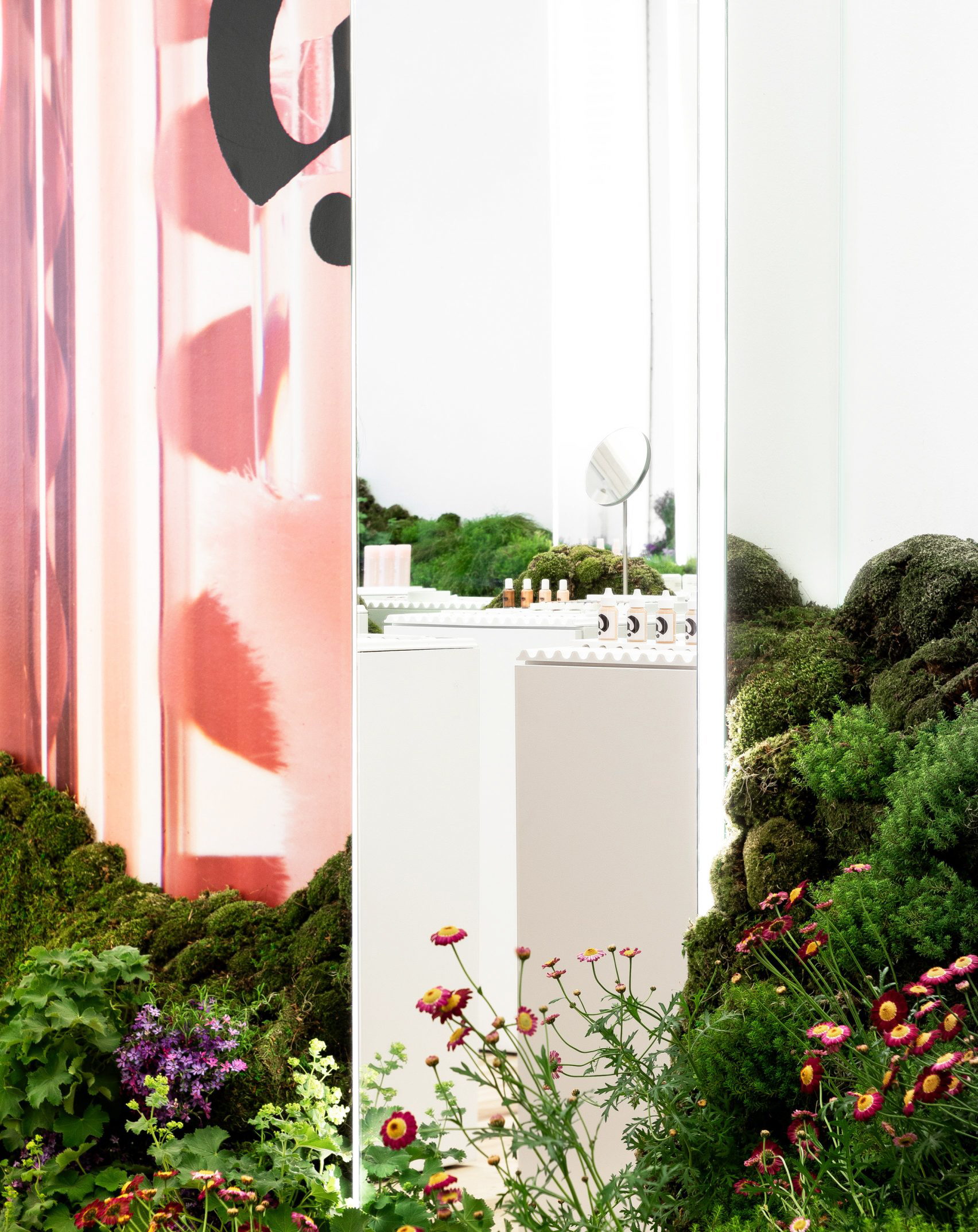 苔や花で覆われた丘が存在する対比が美しいコスメショップの店舗設計